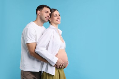 Photo of Pregnant woman and her husband on blue background. Space for text