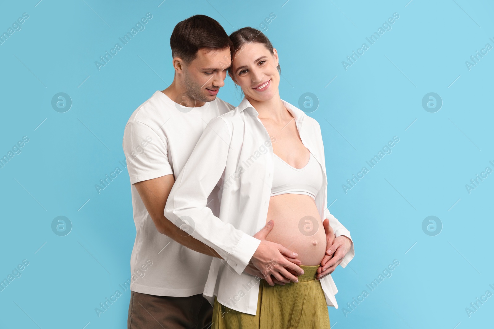 Photo of Pregnant woman and her husband on blue background