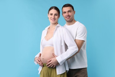 Photo of Pregnant woman and her husband on blue background