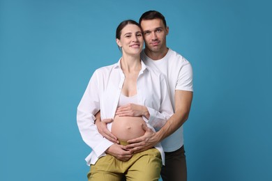 Photo of Pregnant woman and her husband on blue background