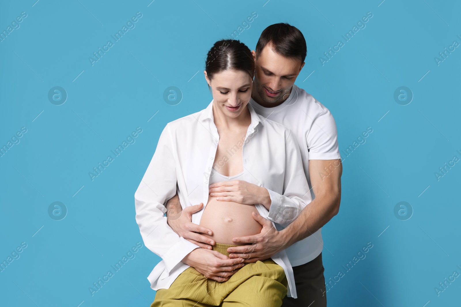 Photo of Pregnant woman and her husband on blue background