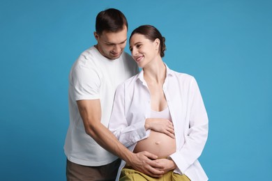 Photo of Pregnant woman and her husband on blue background