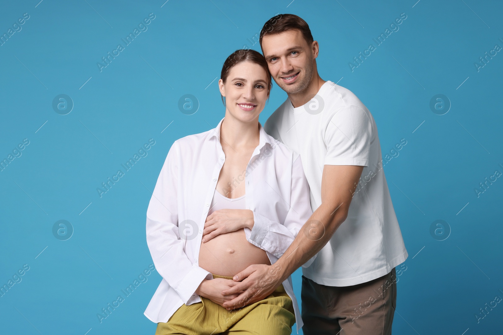 Photo of Pregnant woman and her husband on blue background