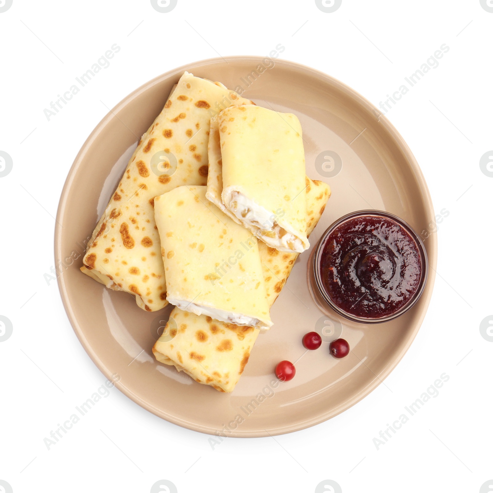 Photo of Delicious rolled crepes with cottage cheese, raisins, jam and cranberries isolated on white, top view