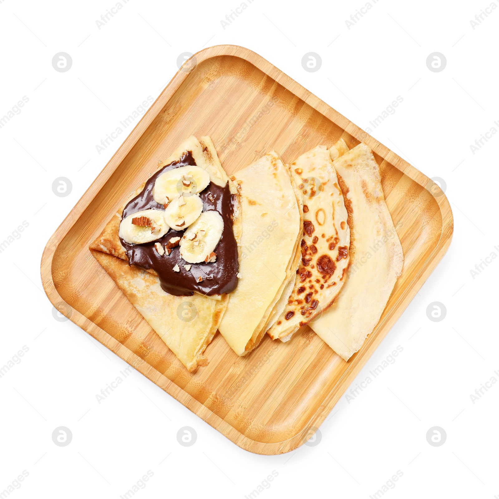 Photo of Delicious crepes with chocolate sauce, banana and almonds isolated on white, top view