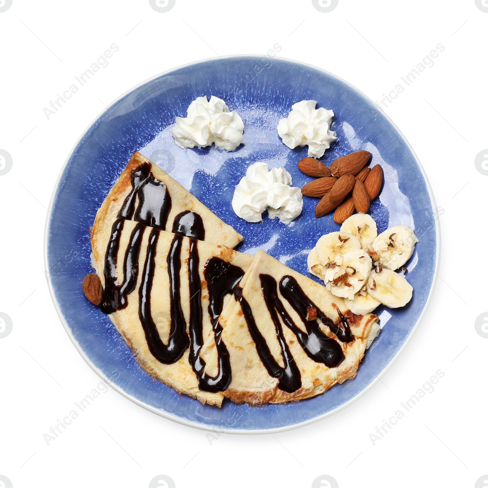 Photo of Delicious crepes with chocolate sauce, banana, almonds and whipped cream isolated on white, top view