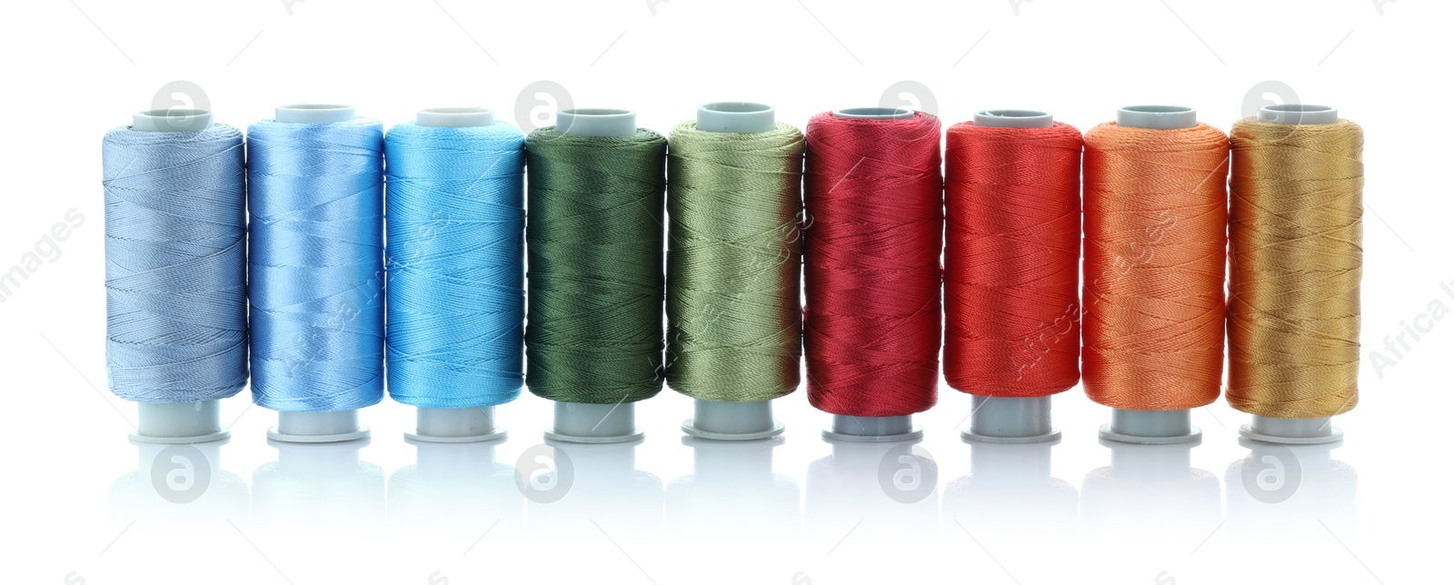 Photo of Spools of bright sewing threads isolated on white