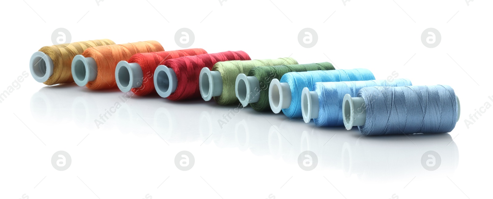 Photo of Spools of bright sewing threads isolated on white