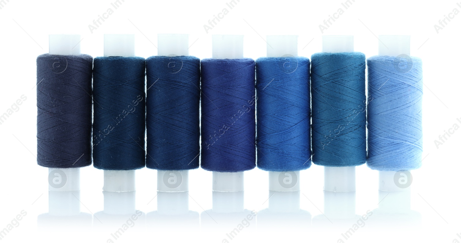 Photo of Spools of bright sewing threads isolated on white