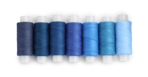 Photo of Spools of bright sewing threads isolated on white, top view