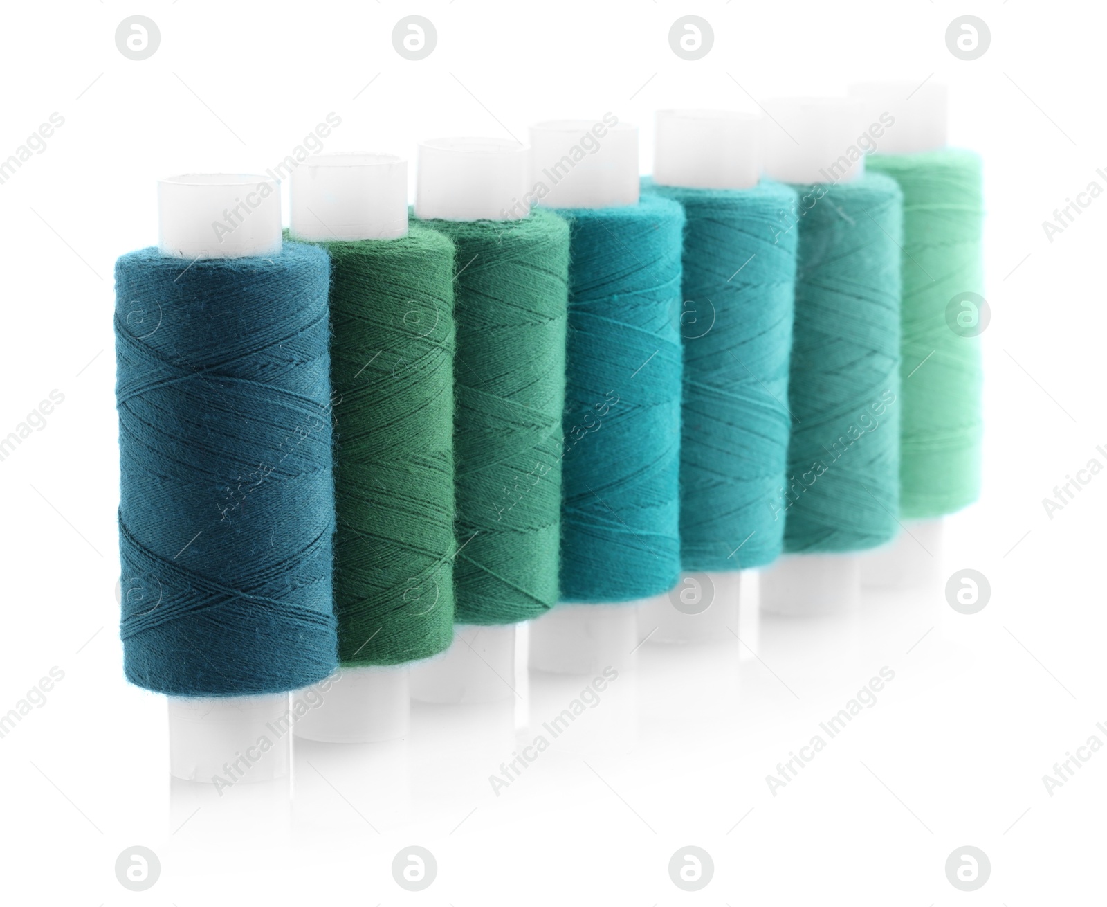 Photo of Spools of bright sewing threads isolated on white