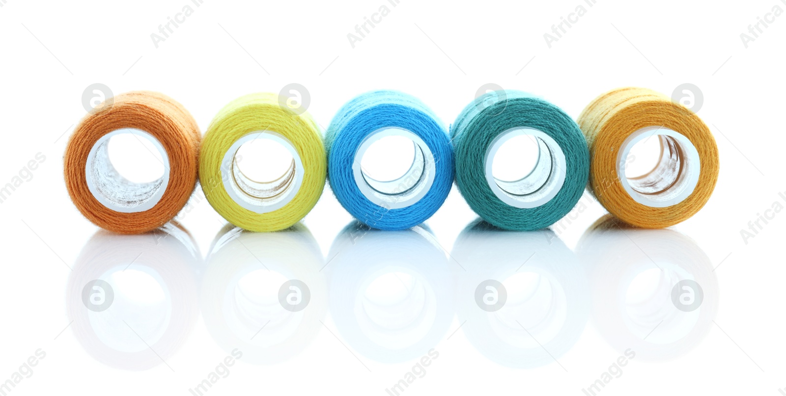 Photo of Spools of bright sewing threads isolated on white