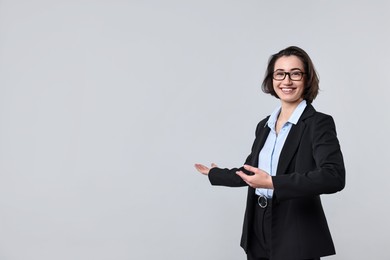 Photo of Happy businesswoman welcoming clients or partners on light grey background