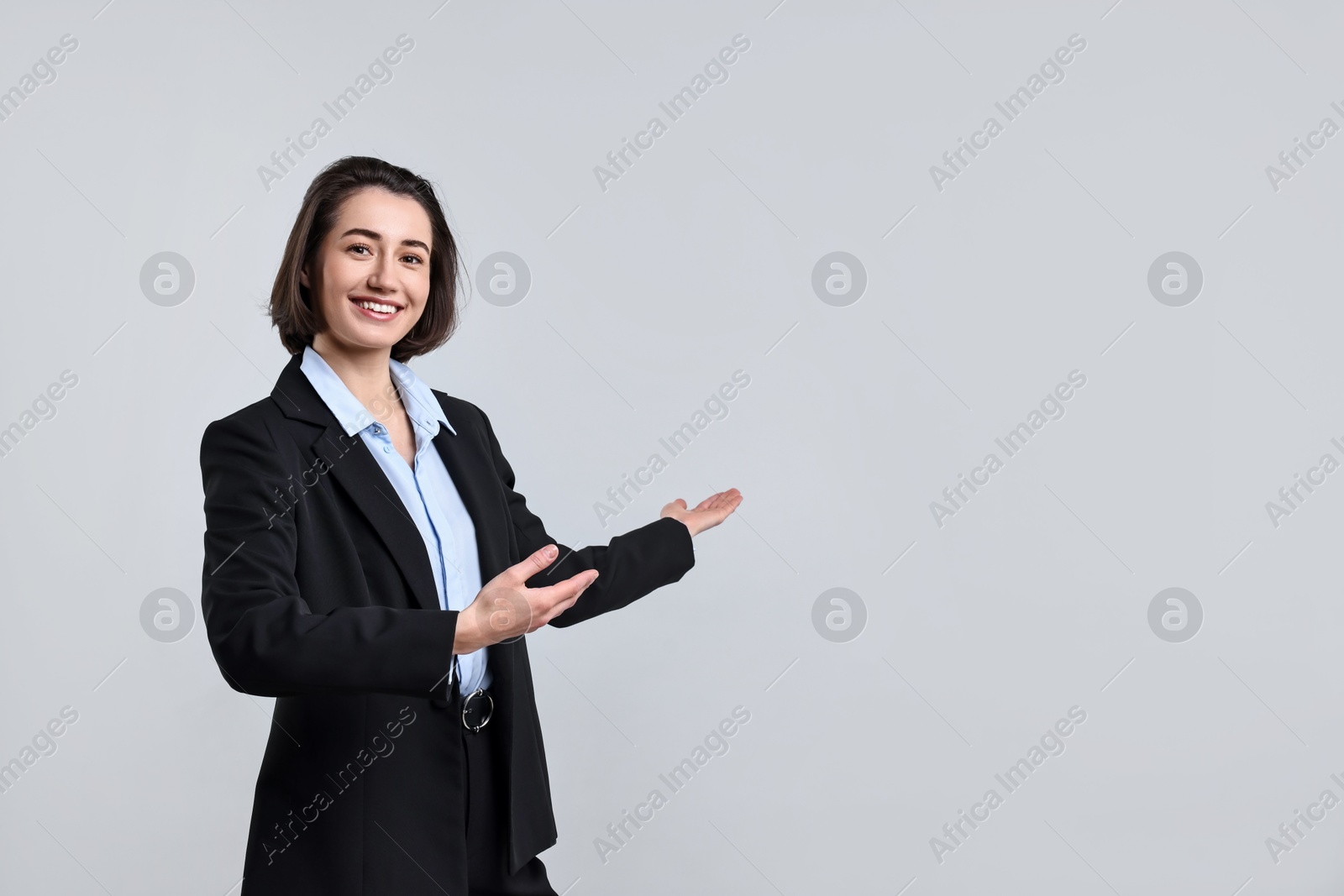 Photo of Happy businesswoman welcoming clients or partners on light grey background