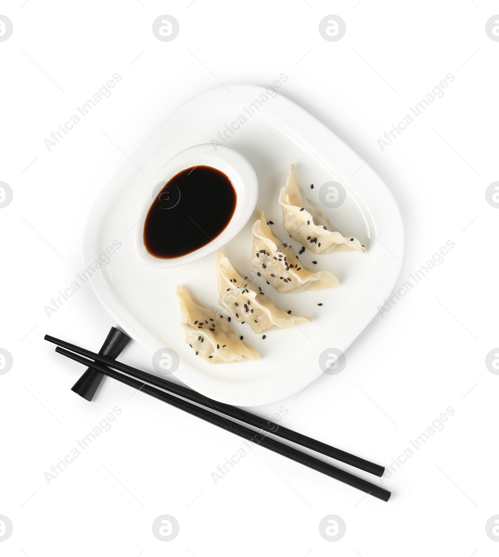 Photo of Tasty gyoza (dumplings), soy sauce and chopsticks isolated on white, top view