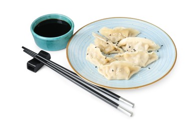 Photo of Tasty gyoza (dumplings), soy sauce and chopsticks isolated on white