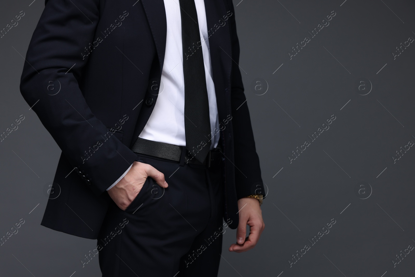 Photo of Man in classic suit on grey background, closeup. Space for text