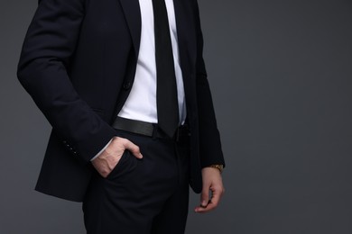 Photo of Man in classic suit on grey background, closeup. Space for text