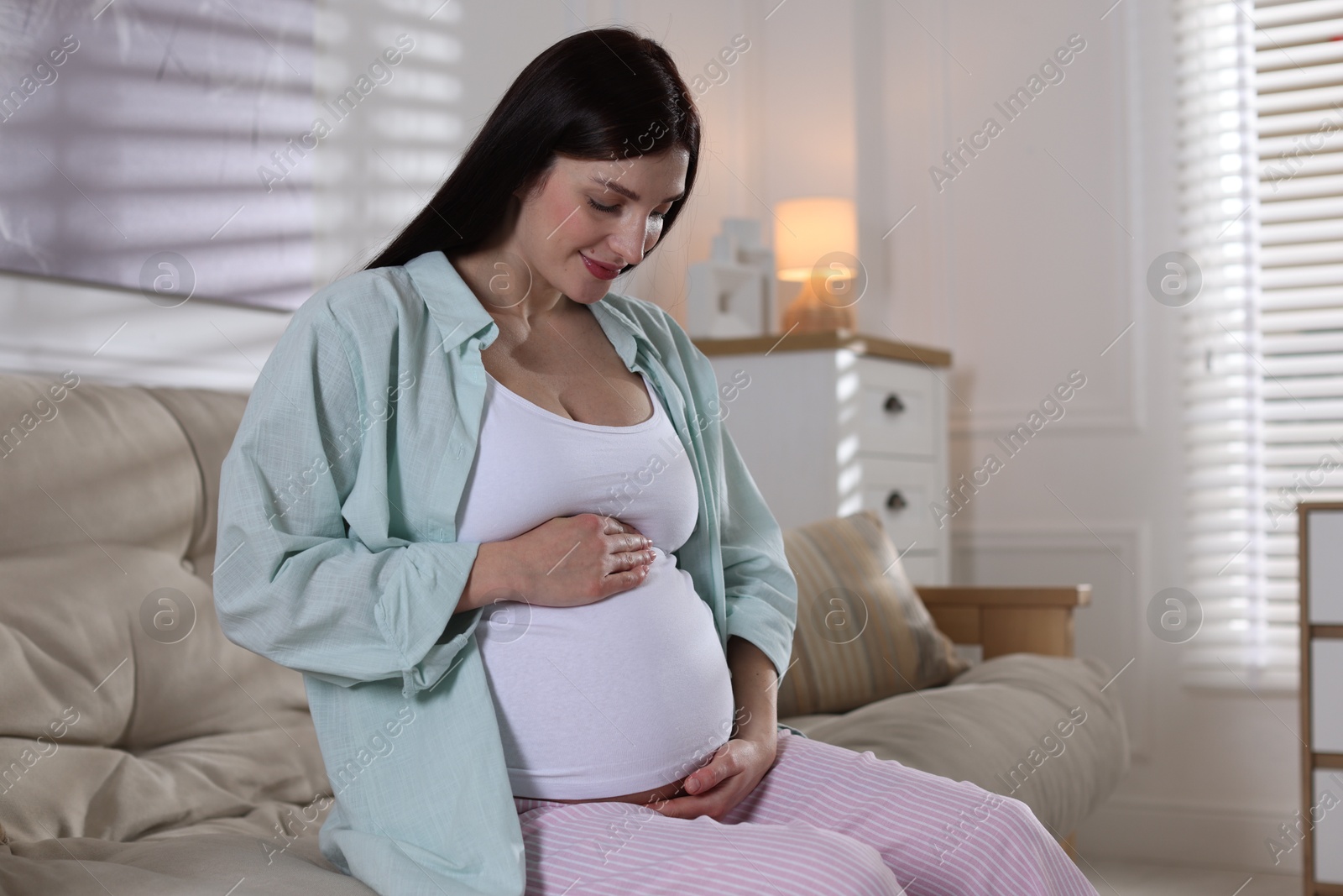 Photo of Beautiful pregnant woman on sofa at home