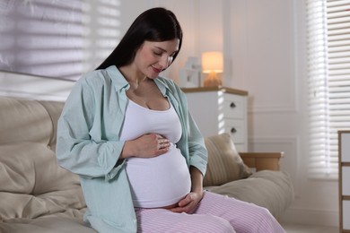 Photo of Beautiful pregnant woman on sofa at home