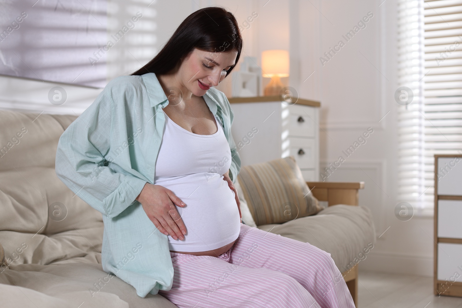 Photo of Beautiful pregnant woman on sofa at home