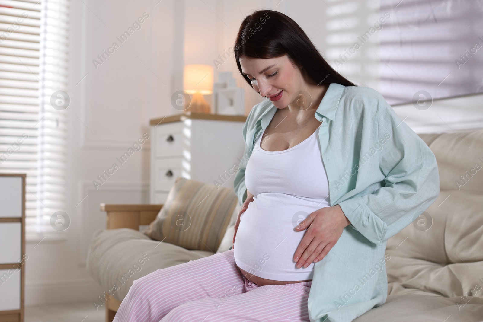 Photo of Beautiful pregnant woman on sofa at home