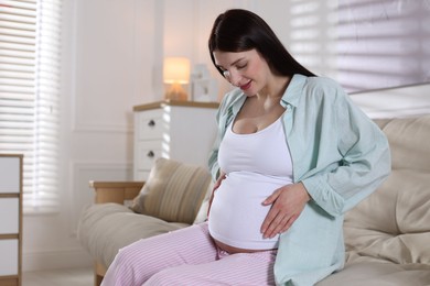 Photo of Beautiful pregnant woman on sofa at home