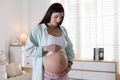 Photo of Beautiful pregnant woman with cute belly at home