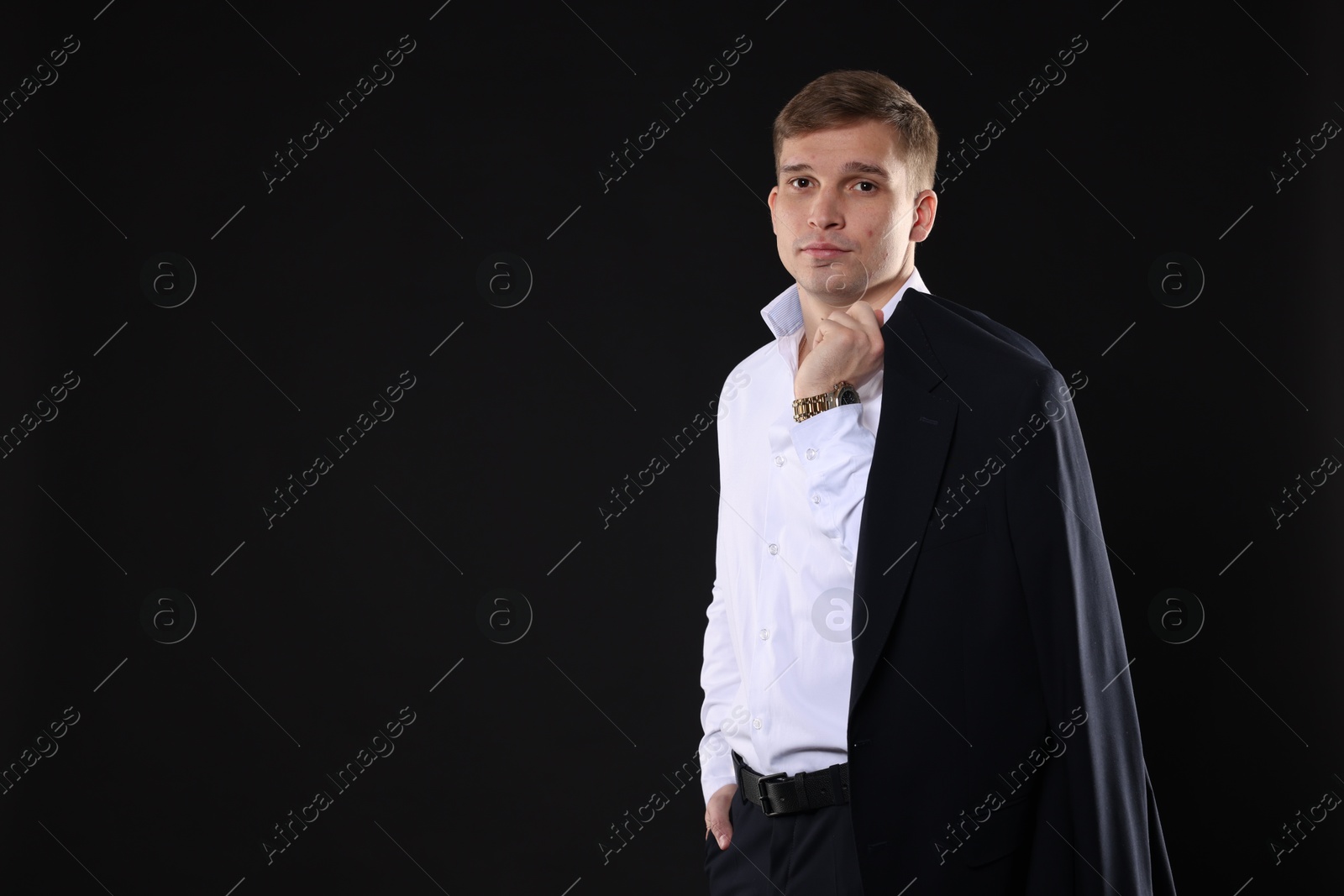 Photo of Man in classic suit on black background. Space for text