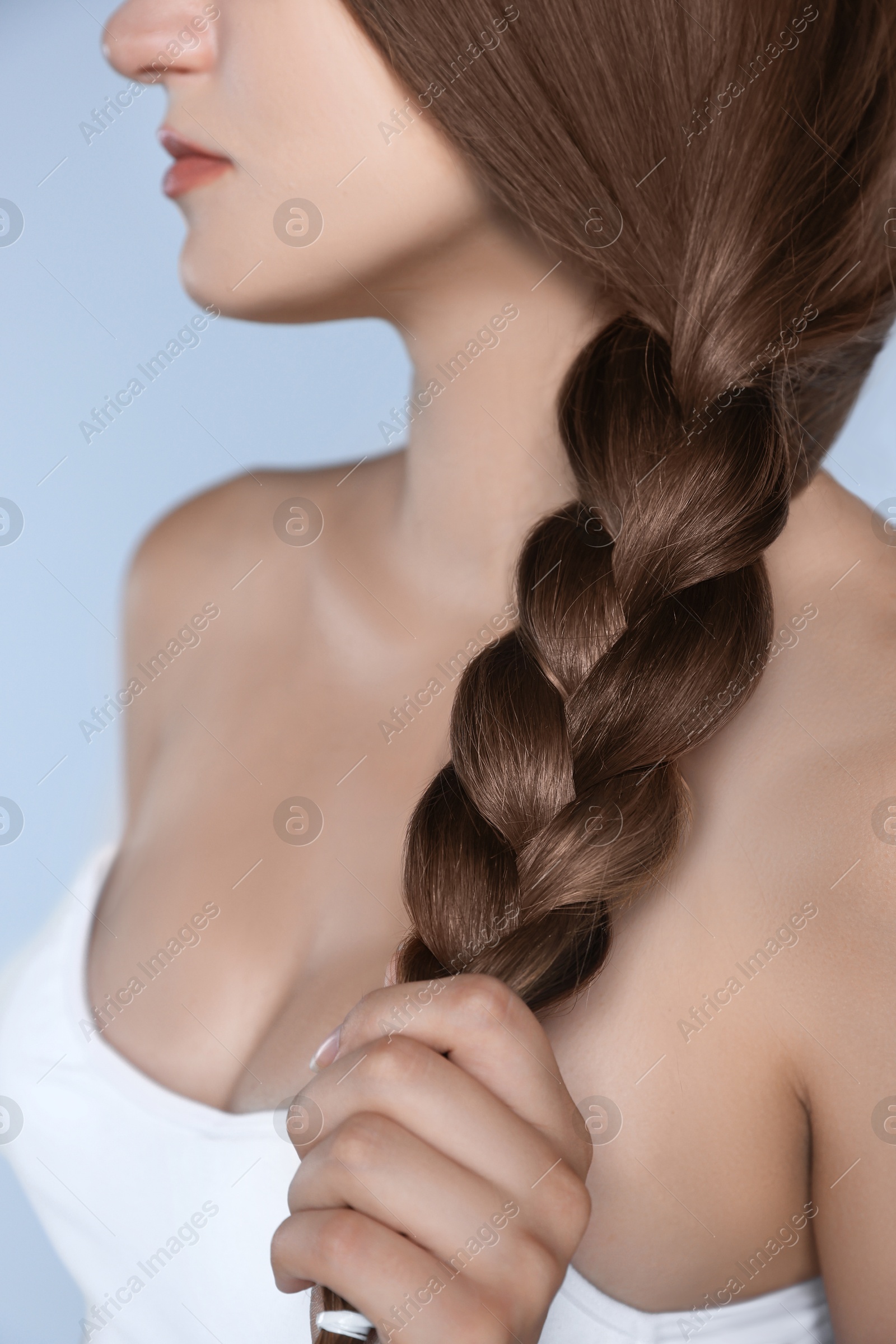 Image of Attractive woman with beautiful hair in mocha mousse shade on grey background, closeup. Trendy color of 2025 year