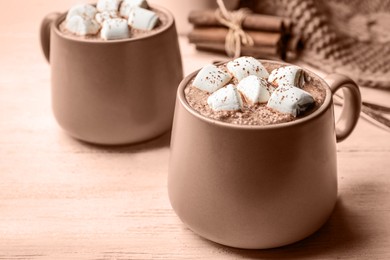 Image of Delicious hot cocoa with marshmallows on table, toned in mocha mousse shade. Trendy color of 2025 year