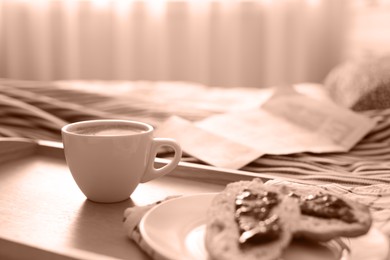 Image of Morning coffee and sandwiches on tray in bedroom, toned in mocha mousse shade. Trendy color of 2025 year