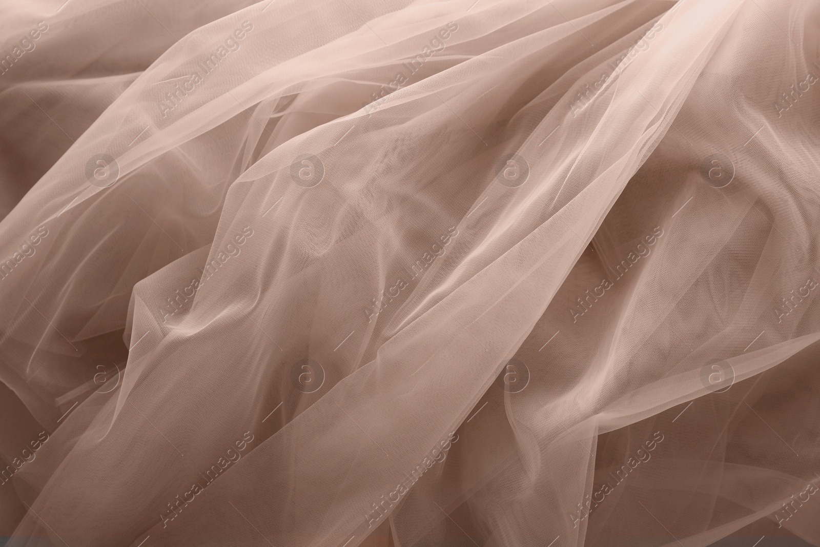 Image of Tulle fabric in mocha mousse shade, closeup. Trendy color of 2025 year