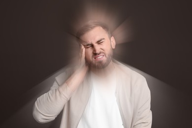 Image of Man suffering from headache and dizziness on dark brown background