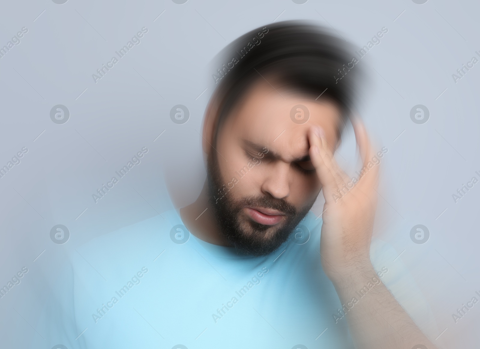 Image of Man suffering from headache and dizziness on grey background