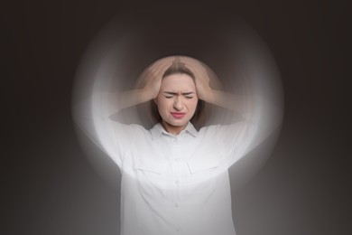 Image of Woman suffering from headache and dizziness on dark brown background