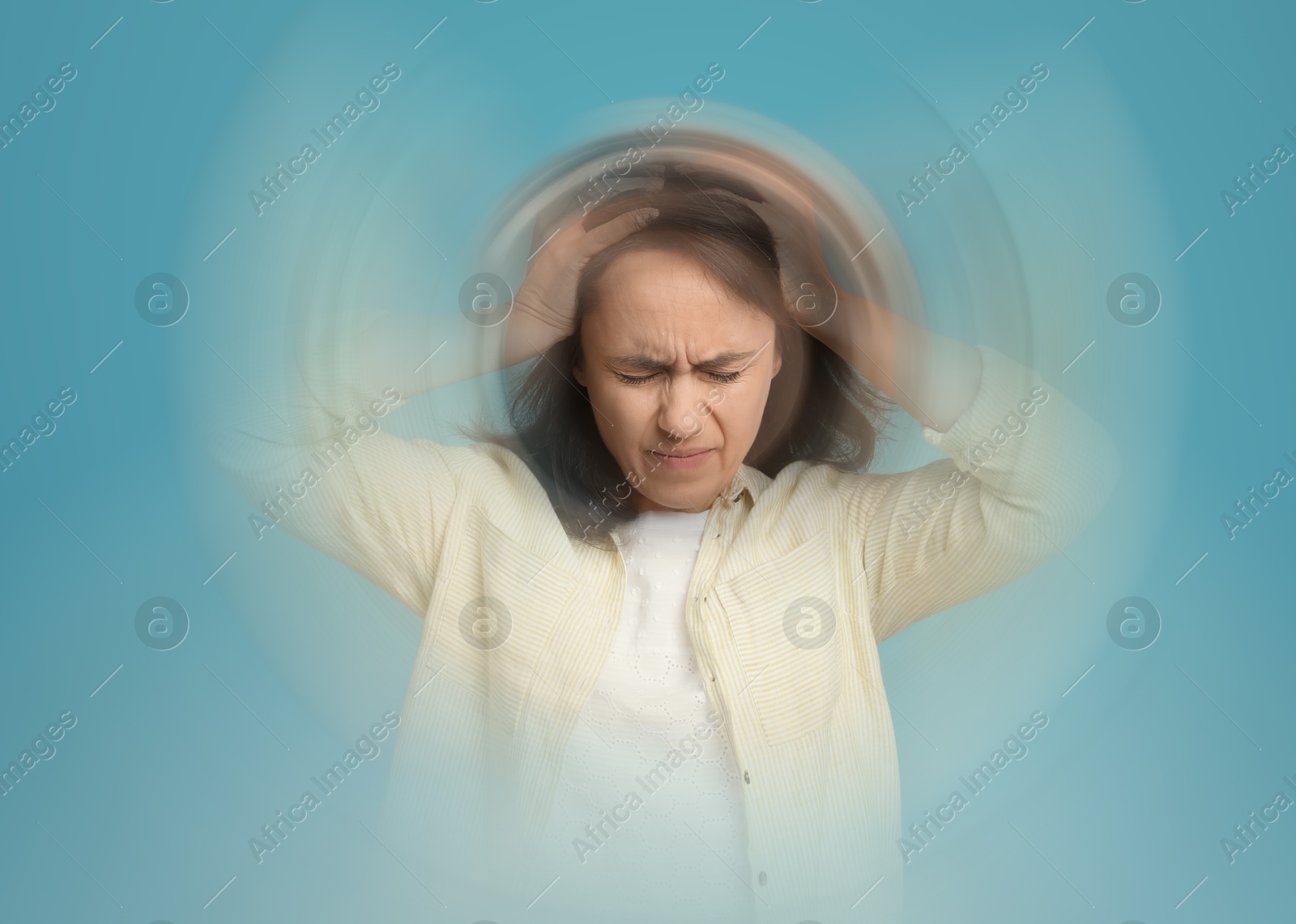 Image of Woman suffering from headache and dizziness on light blue background