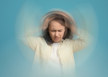 Image of Woman suffering from headache and dizziness on light blue background