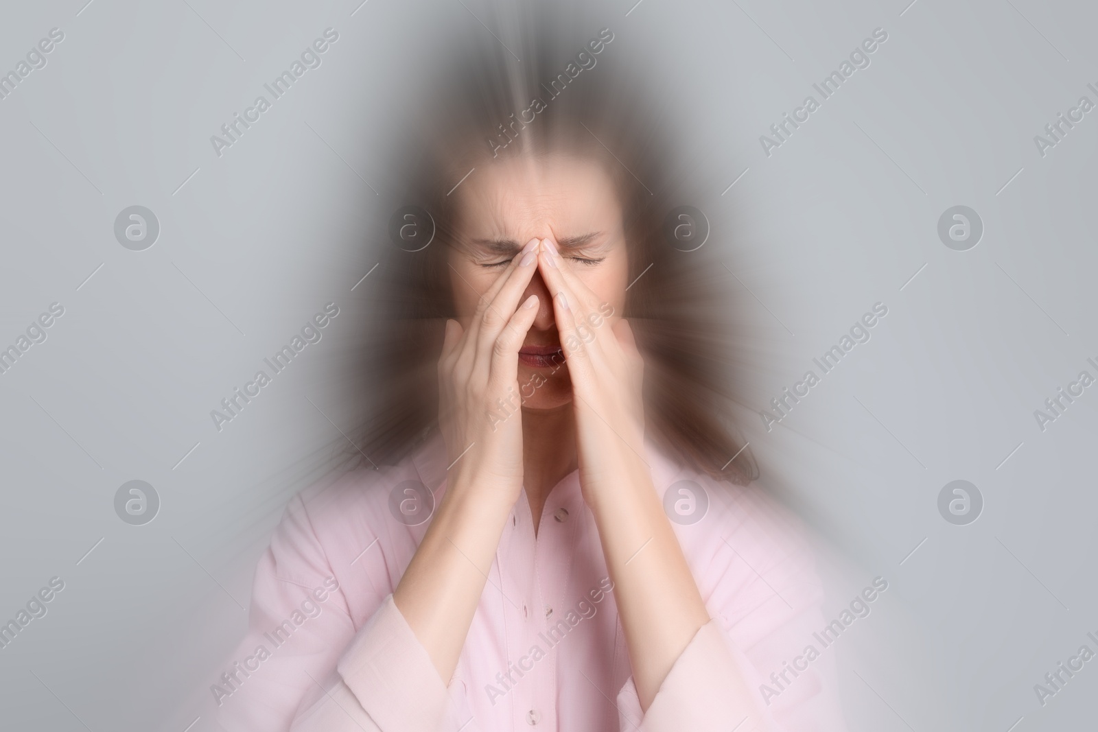 Image of Woman suffering from headache and dizziness on grey background