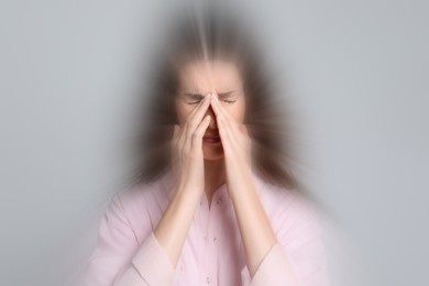 Image of Woman suffering from headache and dizziness on grey background