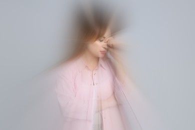 Image of Woman suffering from headache and dizziness on grey background