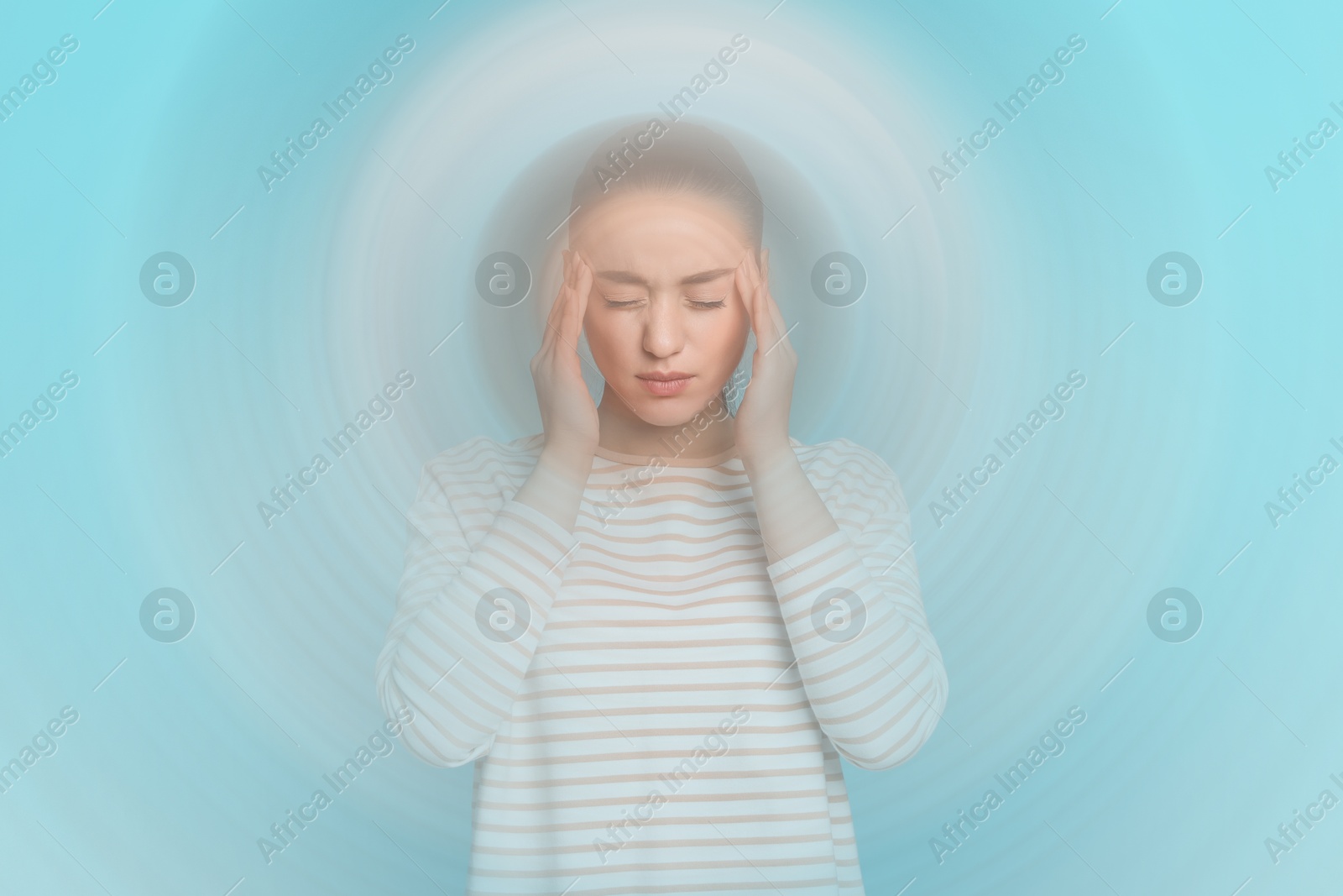 Image of Woman suffering from headache and dizziness on light blue background