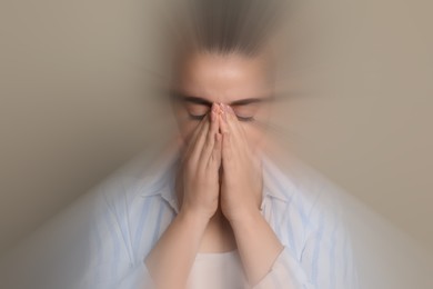 Image of Woman suffering from headache and dizziness on dark beige background