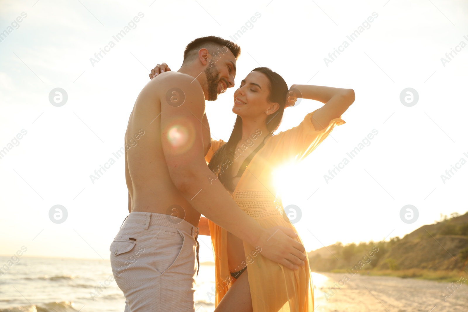 Photo of Happy young couple on beach at sunset