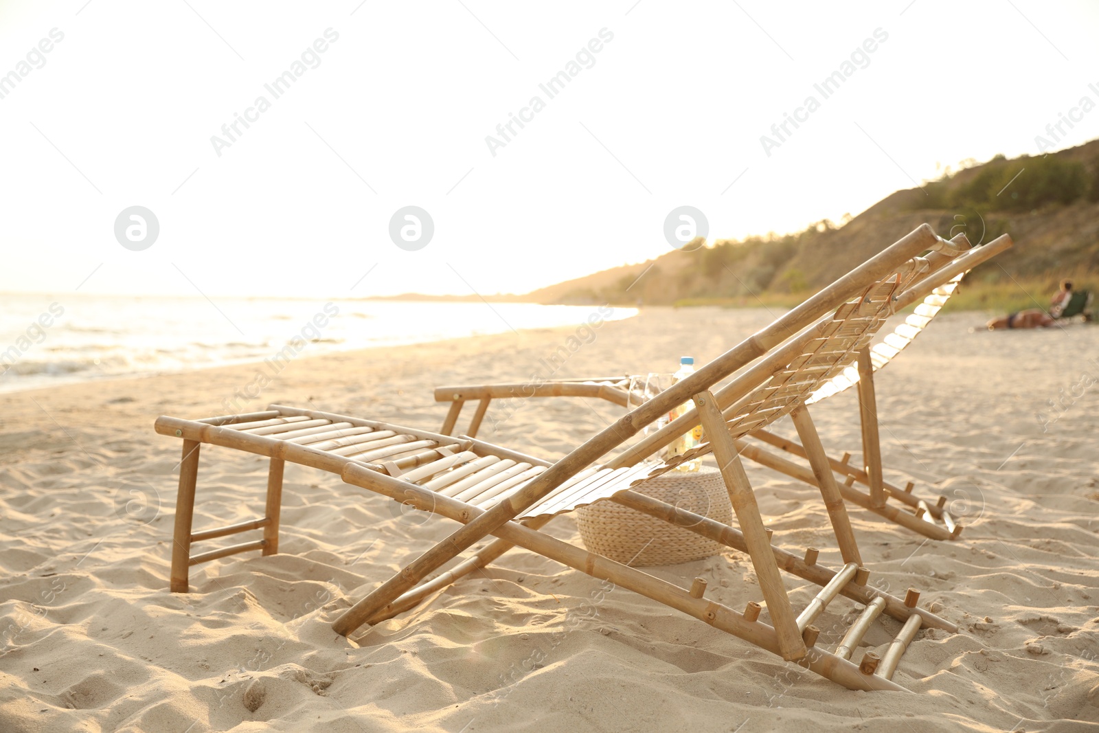 Photo of Empty wooden sunbeds at beach on sunny day