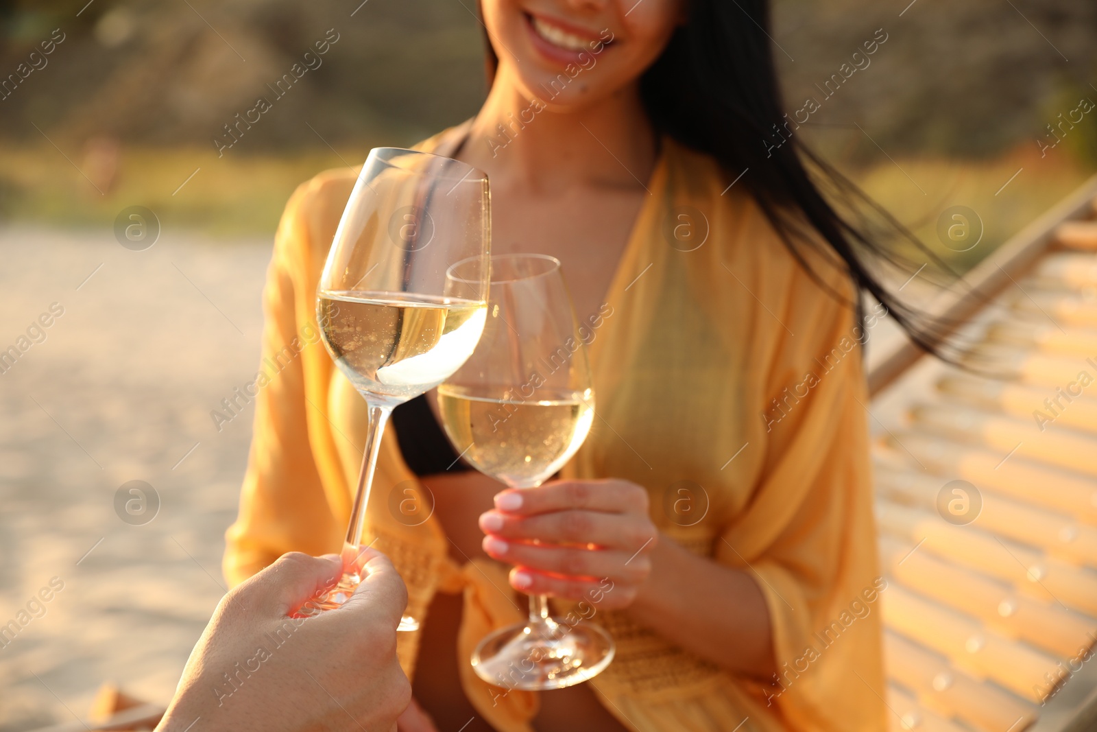 Photo of Romantic couple drinking wine together on beach, closeup