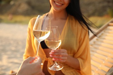 Photo of Romantic couple drinking wine together on beach, closeup