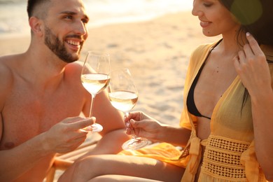 Photo of Romantic couple drinking wine together on beach, closeup