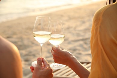 Photo of Romantic couple drinking wine together on beach, closeup