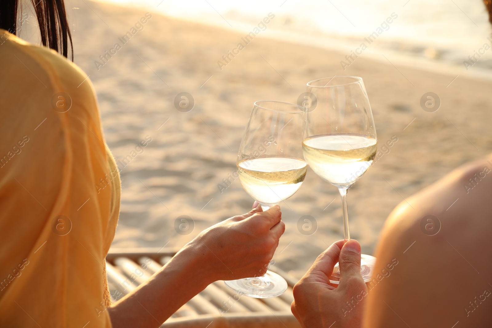 Photo of Romantic couple drinking wine together on beach, closeup